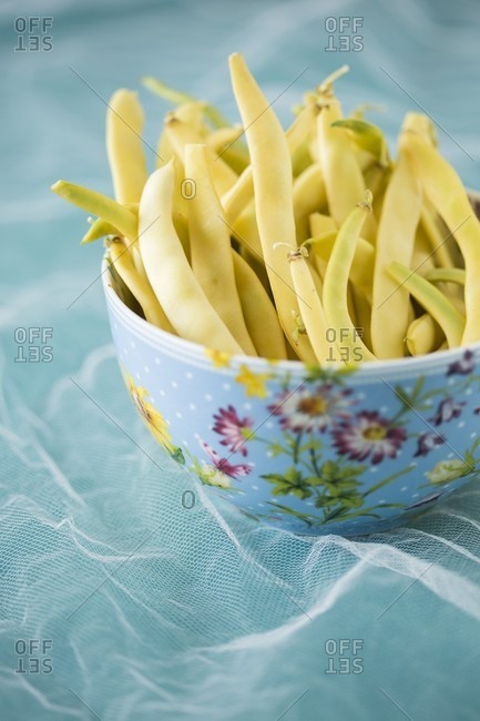 Yellow wax beans in floral patterned bowl