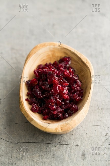 Chopped, dried cranberries in a wooden bowl
