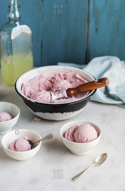 Homemade raspberry ice cream in a bowl and dishes
