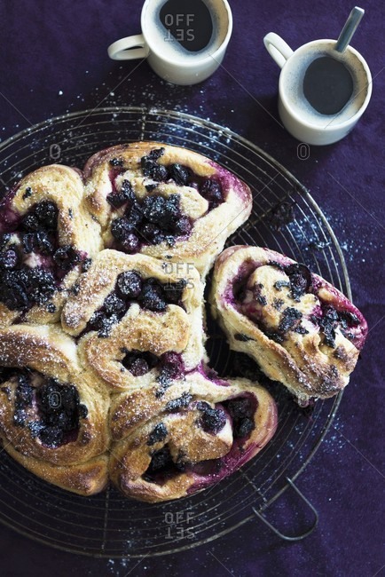 Blueberry pastries with icing sugar served with coffee