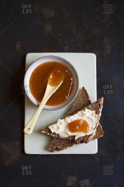 Medlar jam on a bowl and on a slice of toast with cream cheese (seen from above)