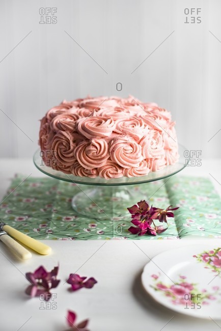A festive pink cream cake on a cake stand
