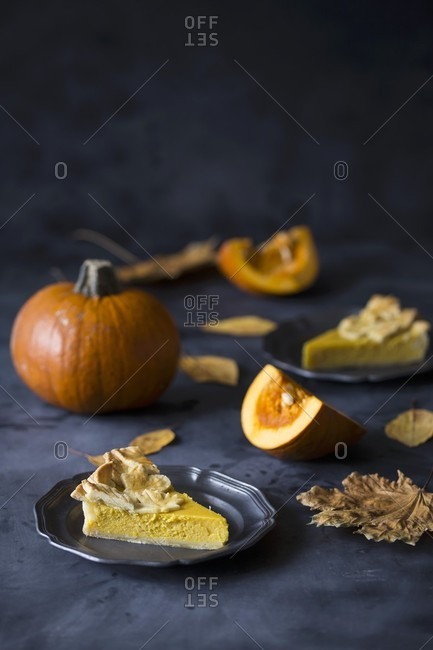 Slices of pumpkin pie decorated with pastry leaves on plates