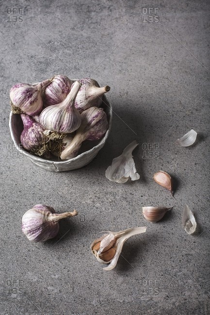 Organic purple garlic in a bowl and next to it