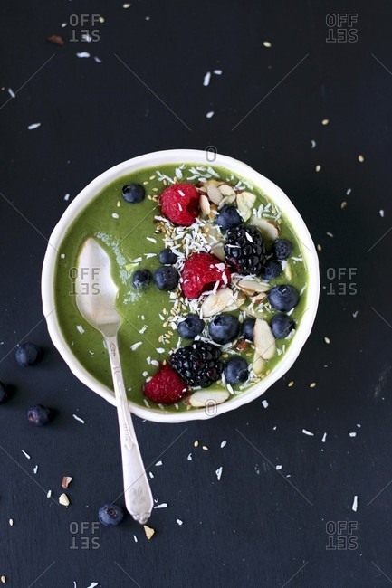 A green smoothie with berries, almonds and coconut
