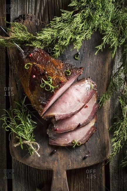Smoked ham with herbs on a wooden board