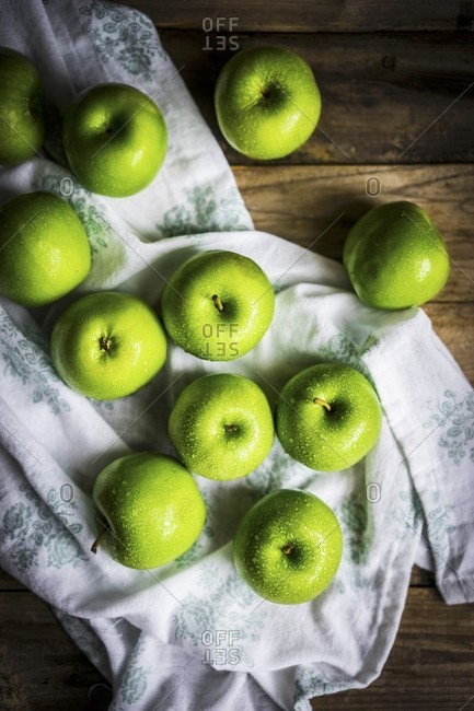 Bright green apples on wooden surface