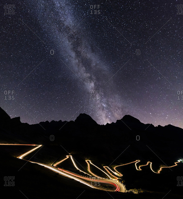 Panorama of the Milky Way and lights of car trace at Stelvio Pass, Valtellina, Lombardy, Trentino Alto Adige, Italy, Europe