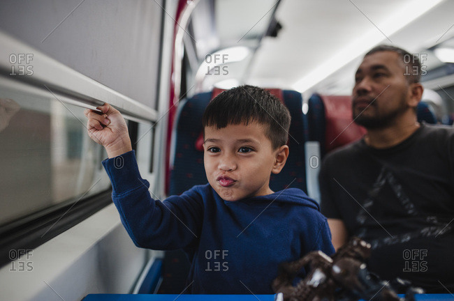 Boy playfully passing time on train ride