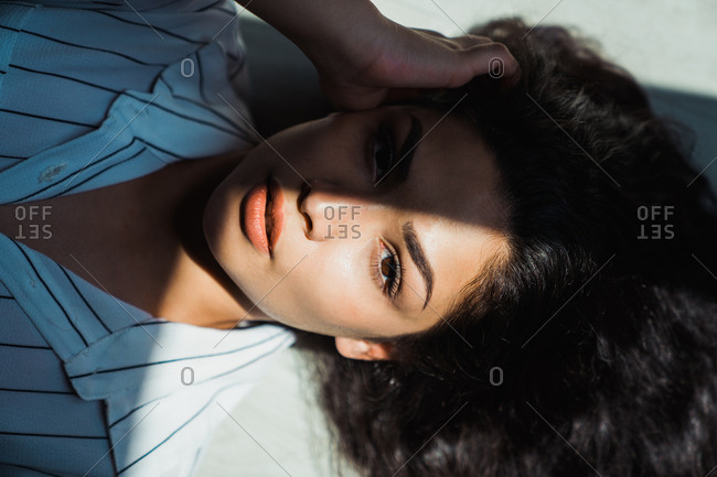Beautiful brunette lying on floor in sunlight