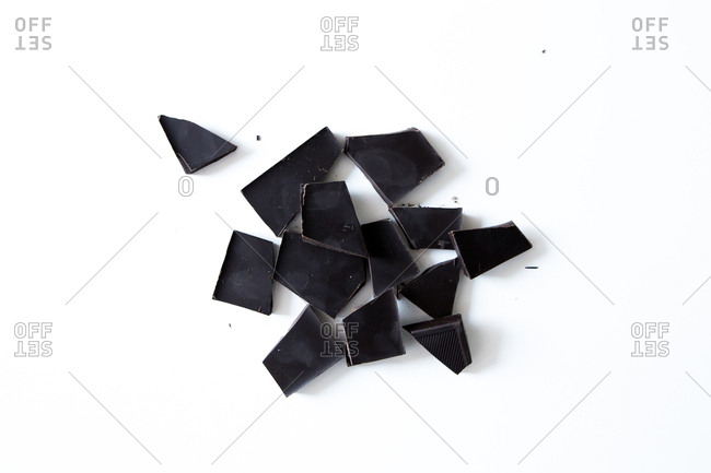 Black chocolate pieces on white surface