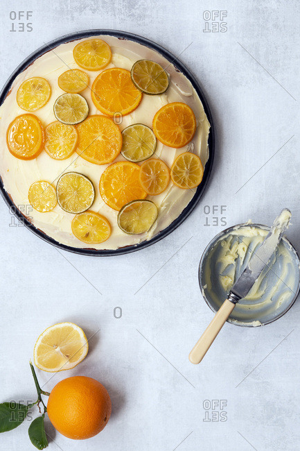 A Round Orange Cake Spread With Butter Icing And Decorated With