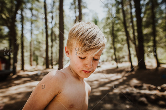 Close up of boy with dirty face in the woods