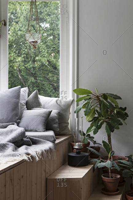 Wooden window seat with cozy throw and pillows