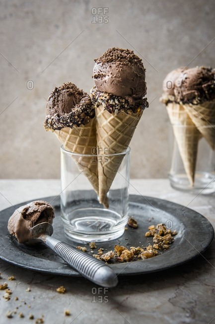 Chocolate ice cream in ice cream cones with an ice cream scoop