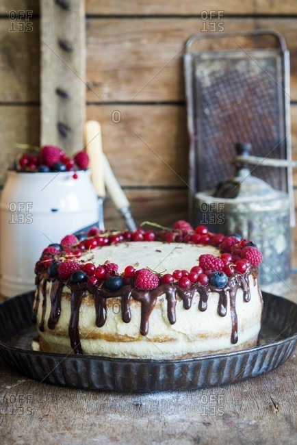 A semi-naked cake with vanilla cream, fresh berries and chocolate ganache