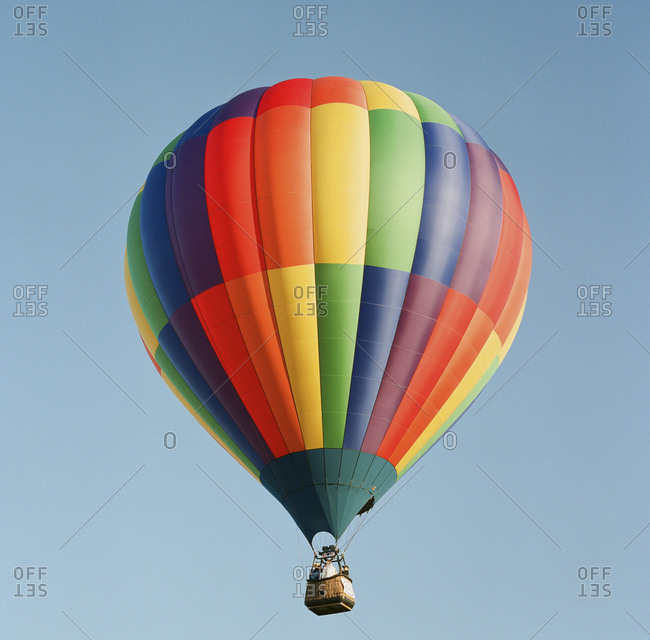 Solitary brightly colored hot air balloon against clear sky