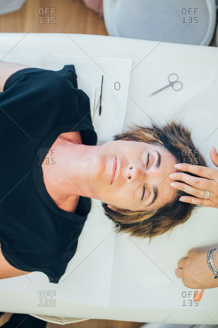 Beautician removing facial hair on a customer - spa treatment, facial hair, epilation concept