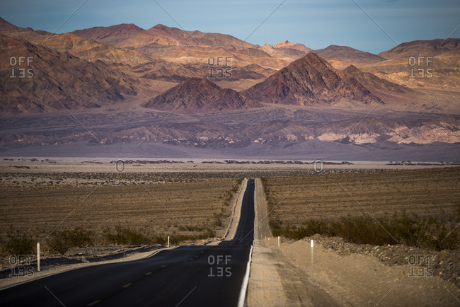 Highway through Death Valley with mountains in the distance, California, United States of America, North America