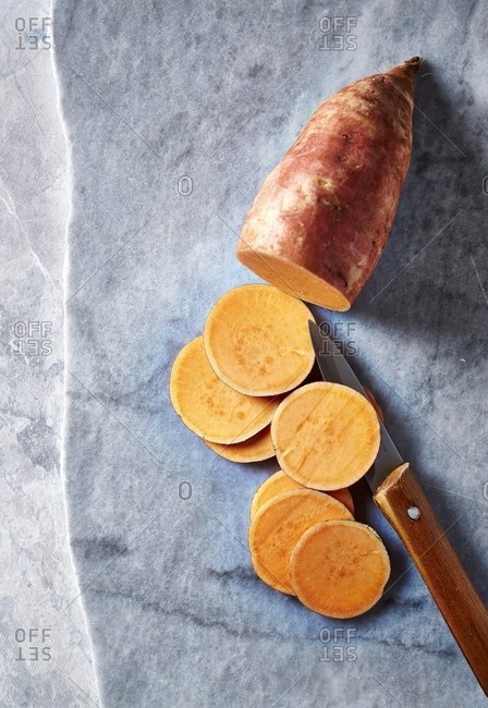 Half a raw sweet potato and sweet potato slices
