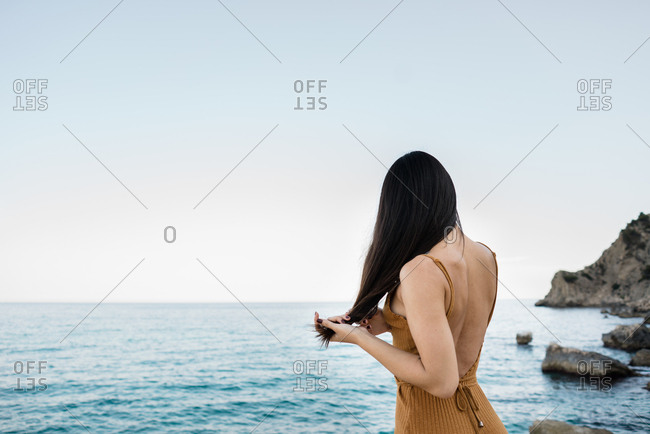 Beautiful stylish brunette on rocky coast