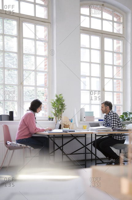 Colleagues working at desk in a loft office