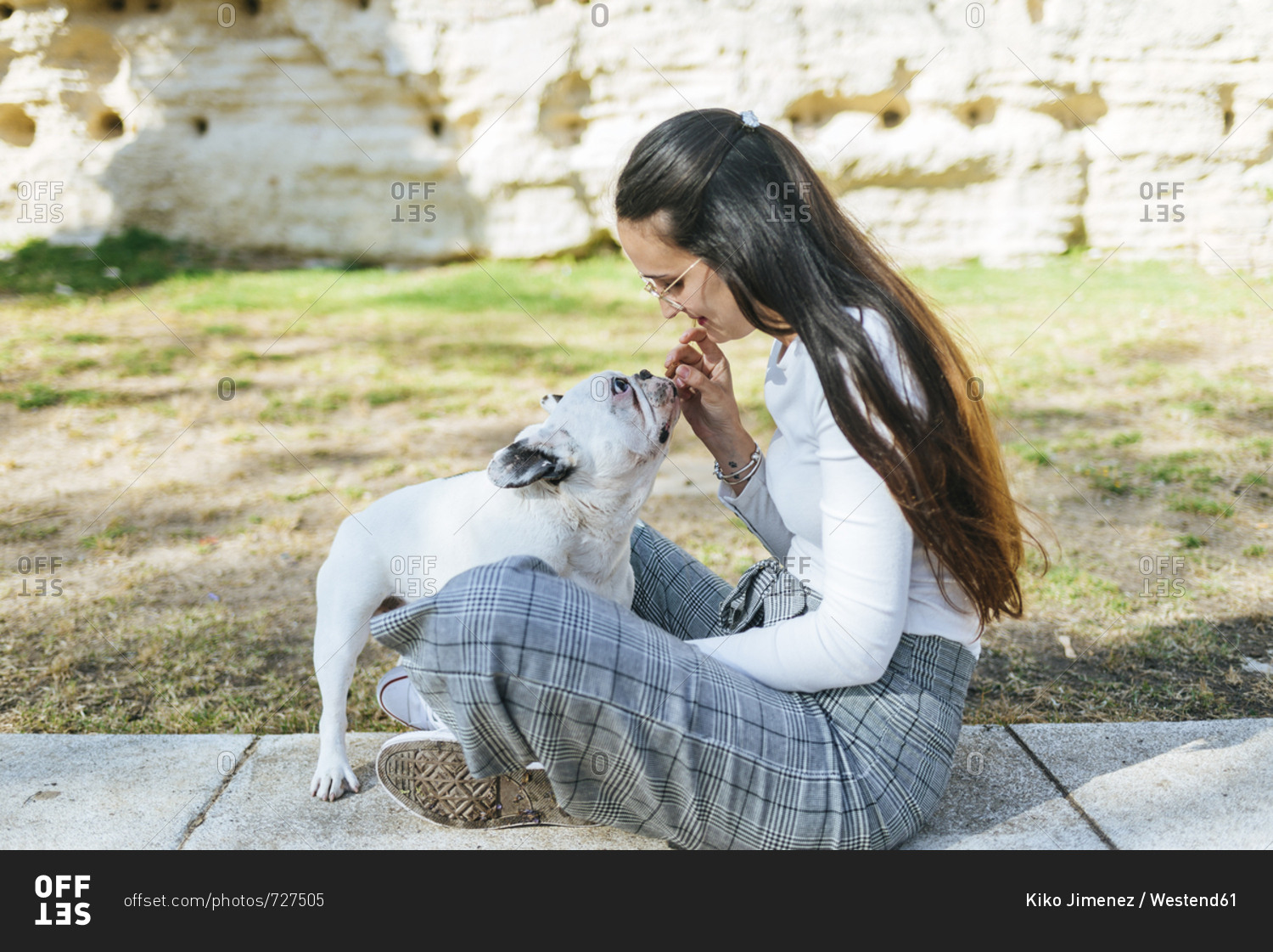 Woman feeding her dog outdoors
