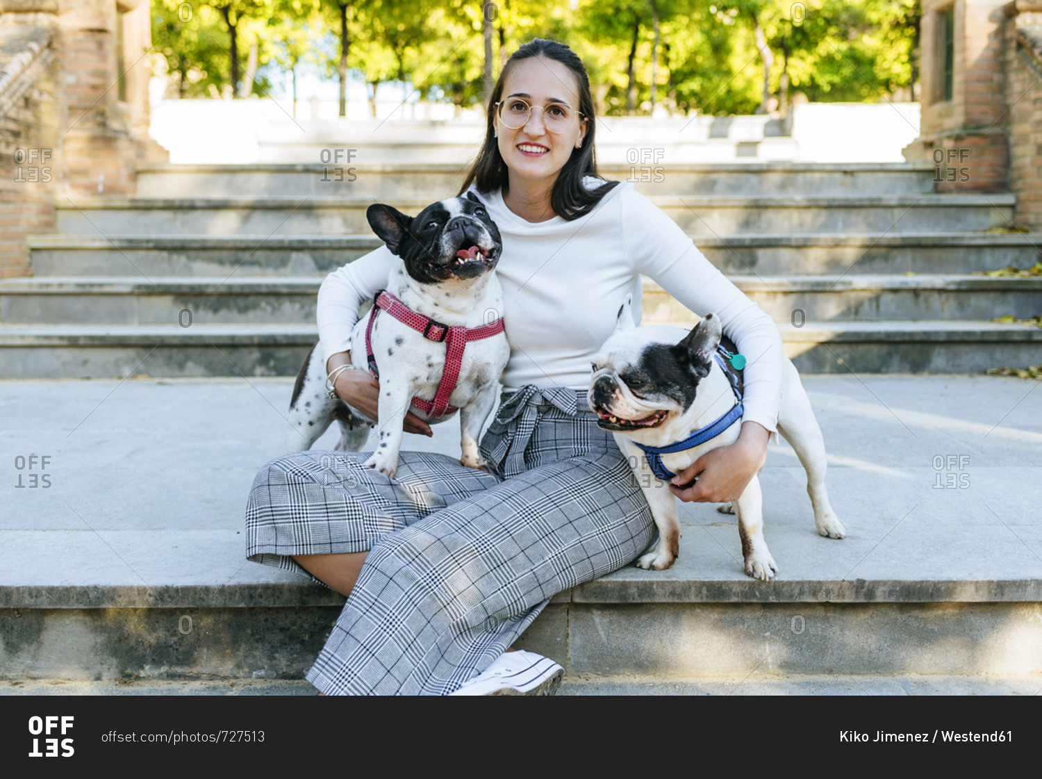 Portrait of woman sitting in the park with her two dogs