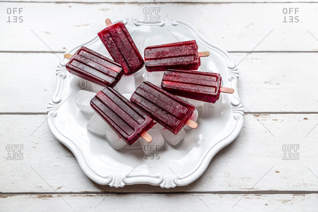 Cherry ice lollies on ice cubes and plate
