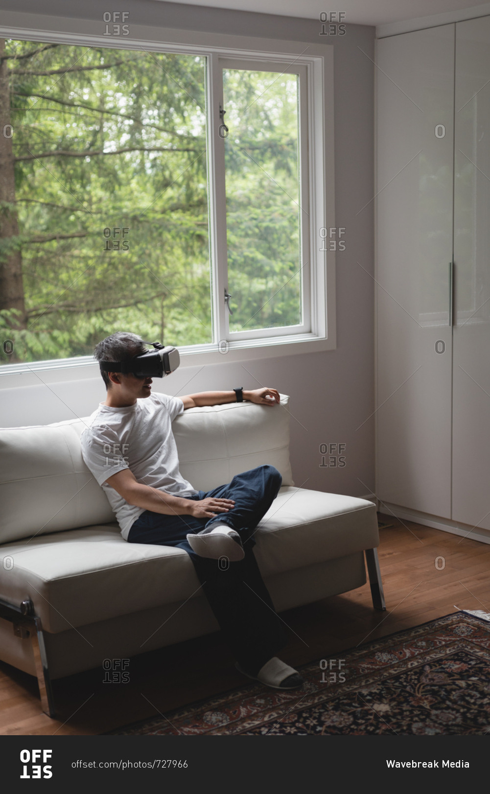 Man using virtual reality headset in living room at home
