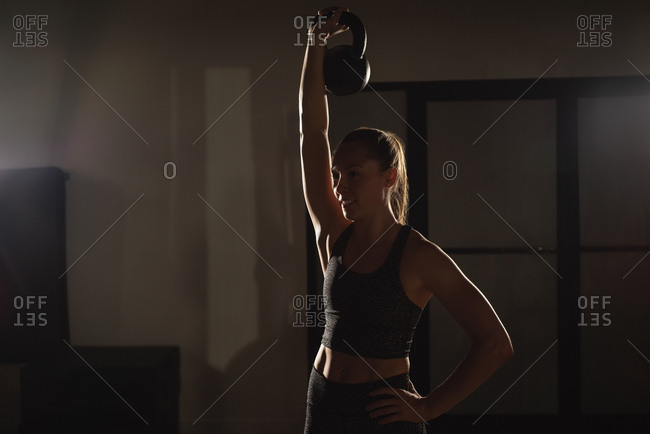 Woman doing exercises with kettlebell in gym