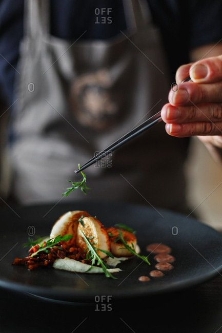 Chef topping scallop dish