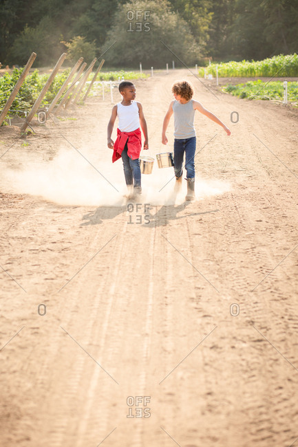 Two brothers walking on dusty farm path