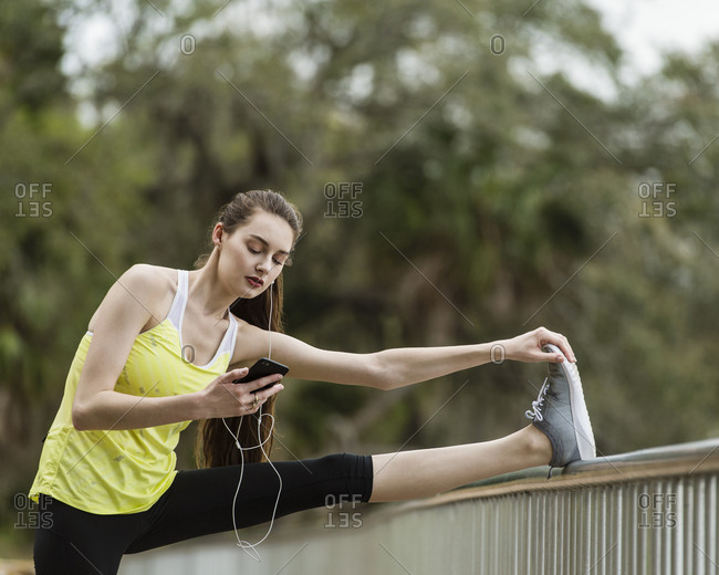 Confident woman using mobile phone while exercising at park