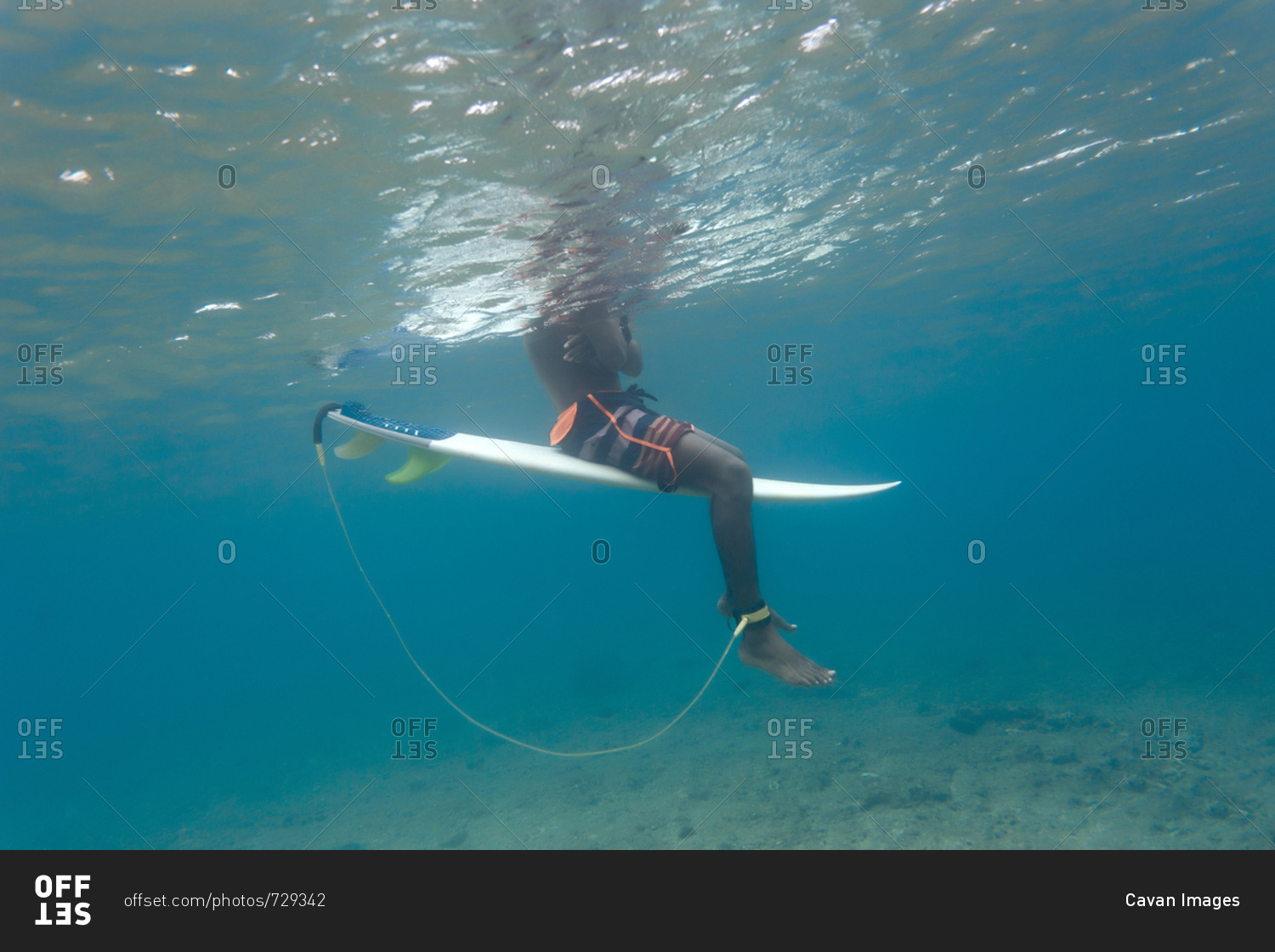 Low section of man surfing in sea at Maldives