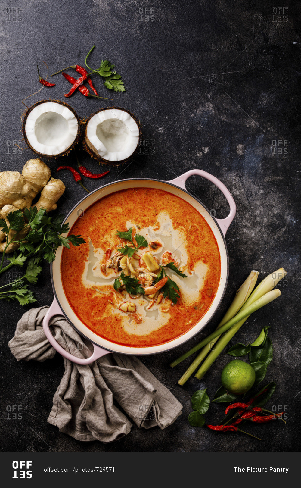 Tom Yam kung Spicy Thai seafood soup with shrimp, coconut milk and lemon grass in casserole dish copy space