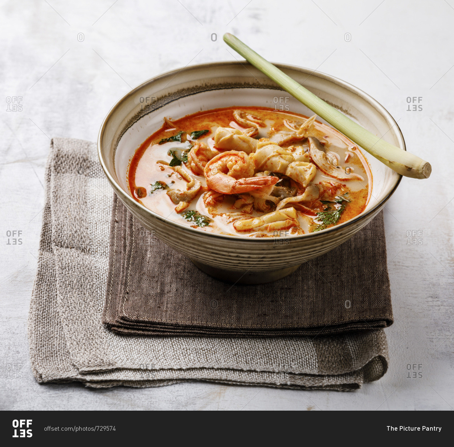 Tom Yam kung Spicy Thai seafood soup with shrimp, coconut milk and lemon grass in bowl