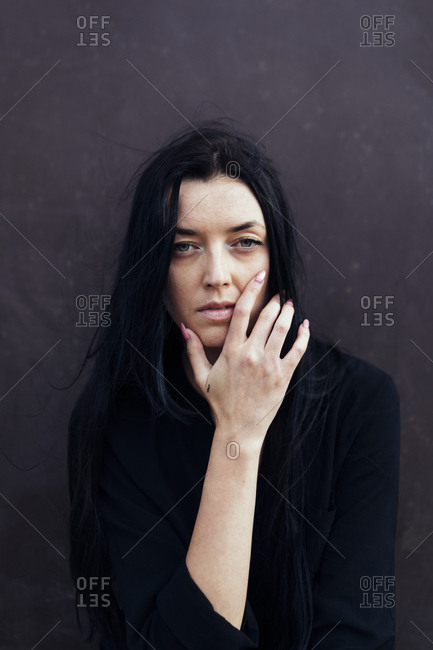 Woman with long dark hair in front of dark background