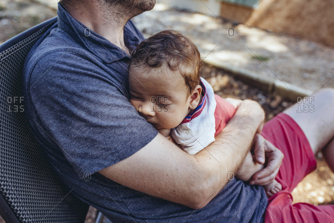 Father cuddling with baby boy outdoors