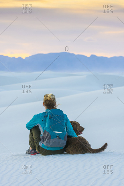 Woman and dog hiking in White Sands National Monument, Alamogordo, New Mexico, USA