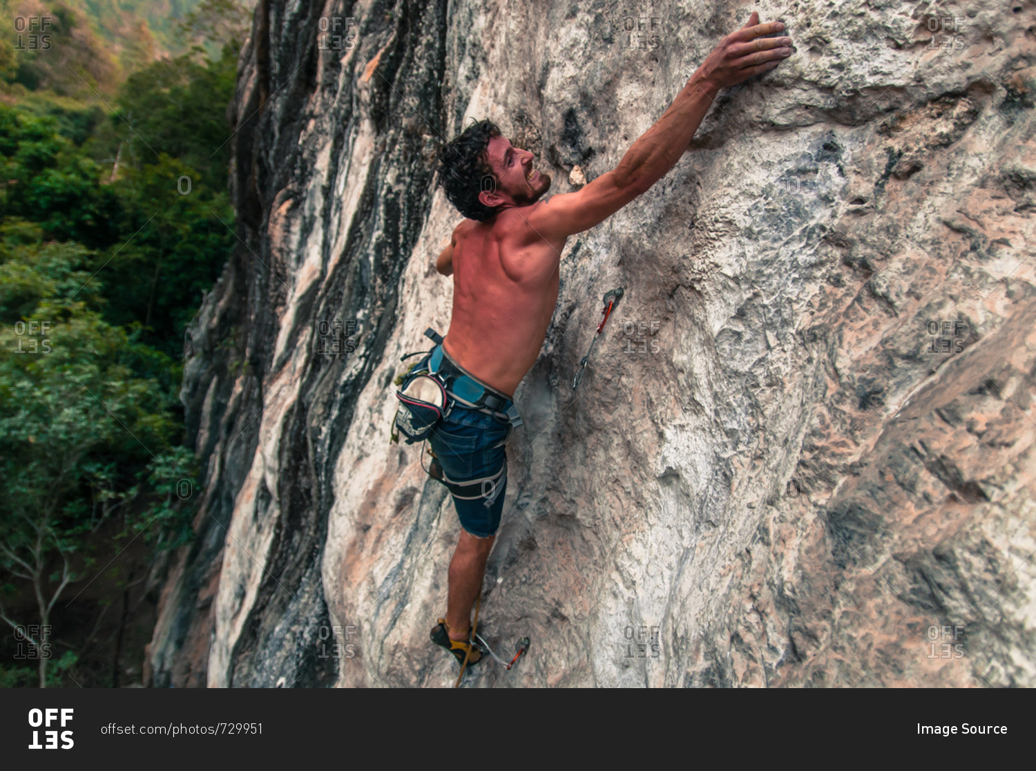 Man sport climbing on limestone, Thakhek, Laos