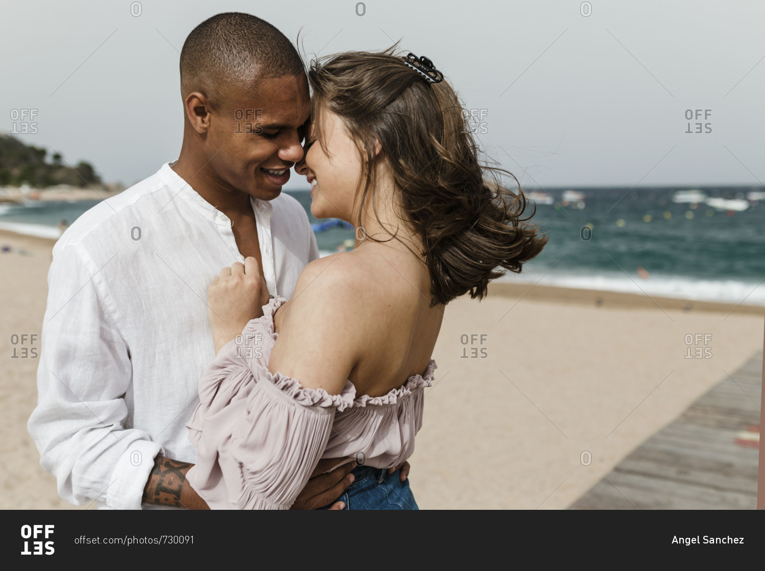 An interracial couple standing on the beach