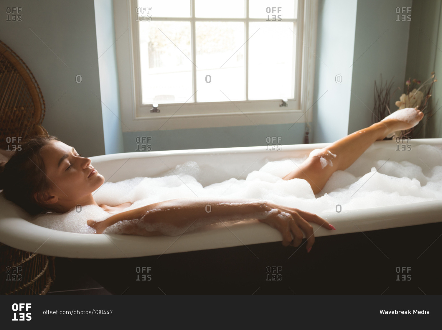 Woman taking a bath in bath tub at home