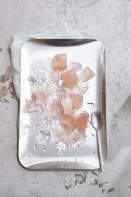 Rose wine ice cubes and ice splinters on a silver tray