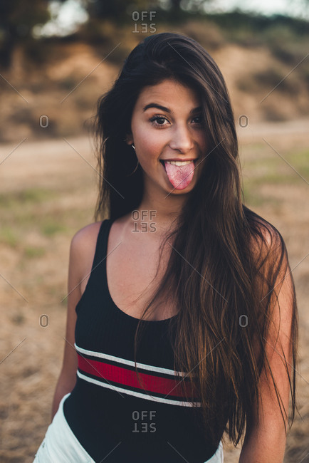 Studio Portrait Of Cute Teen Girls Sticking Out Tongue by Stocksy