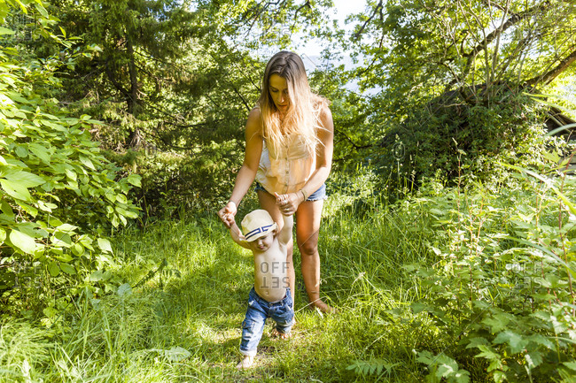 Mother helping baby boy to walk