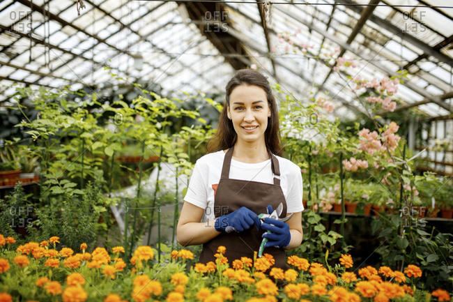 Woman in greenhouse standing with marigolds