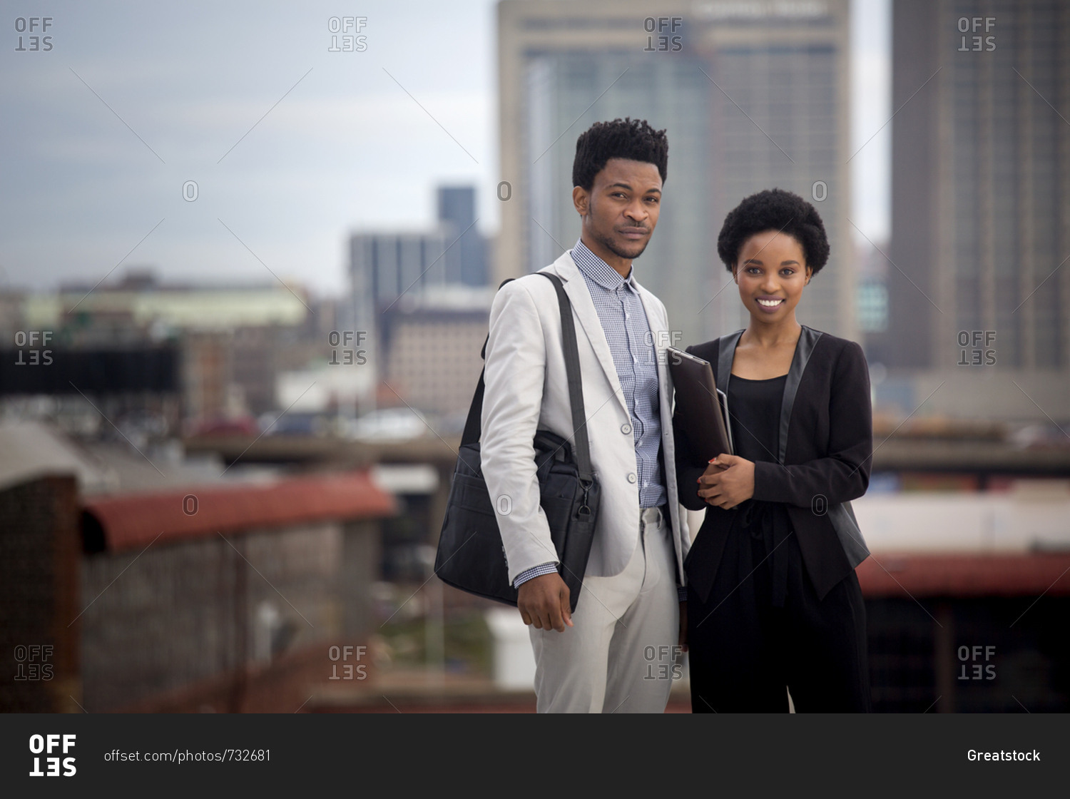 Business man and woman standing on rooftop