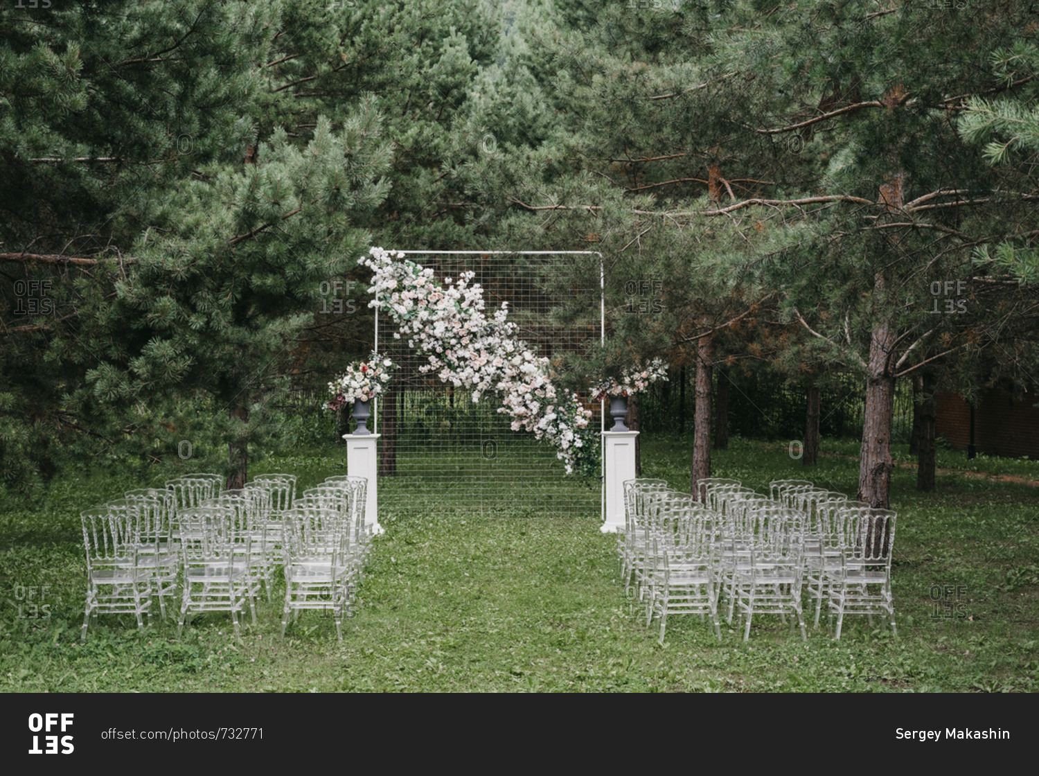 Floral backdrop and seats at an outdoor wedding ceremony