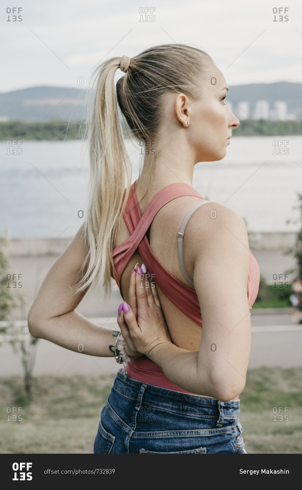 Young blonde woman doing reverse prayer yoga pose